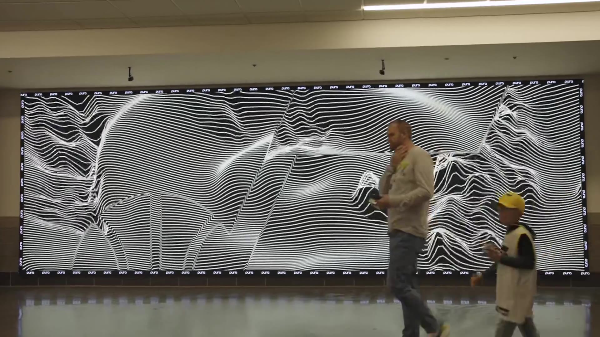 The Pura wall in the Delta Center concourse running the Boom effect as people walk past
