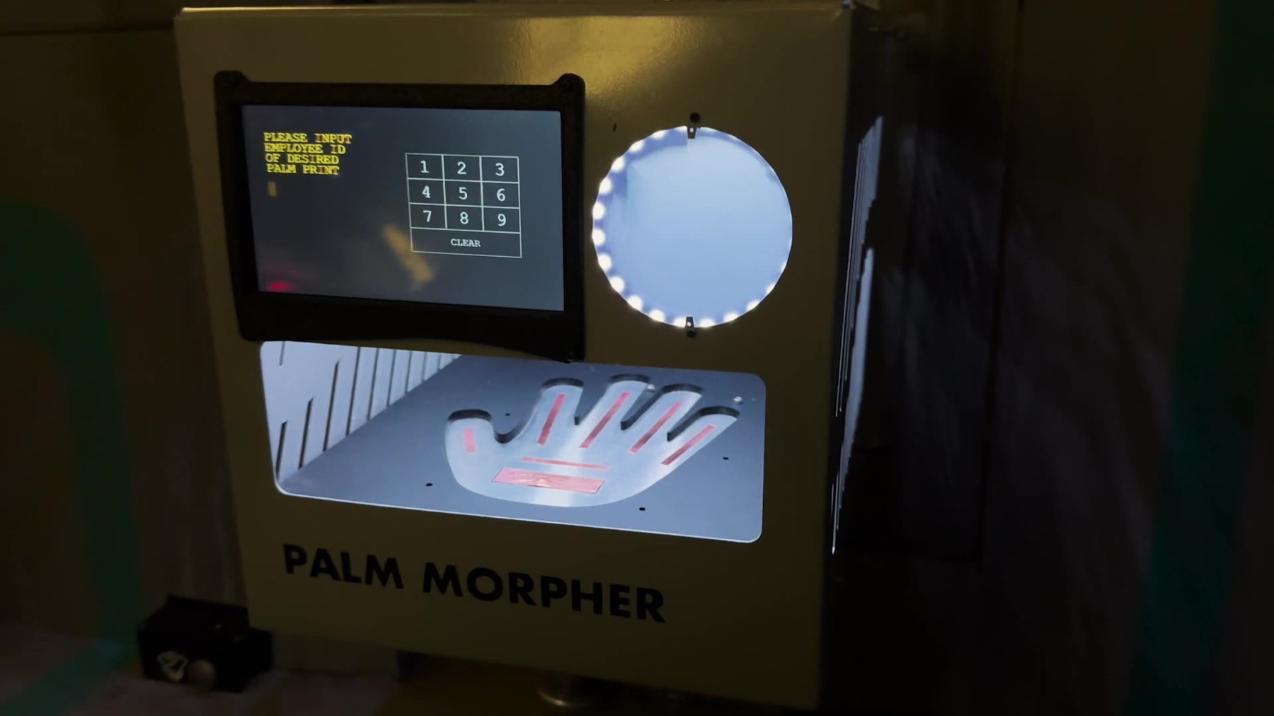 A tan console labeled PALM MORPHER with a small screen reading PLEASE INPUT EMPLOYEE ID OF DESIRED PALM PRINT, a numeric keypad, a circular ring light, and a metal panel with a hand-shaped conductive/capacitive sensor cutout