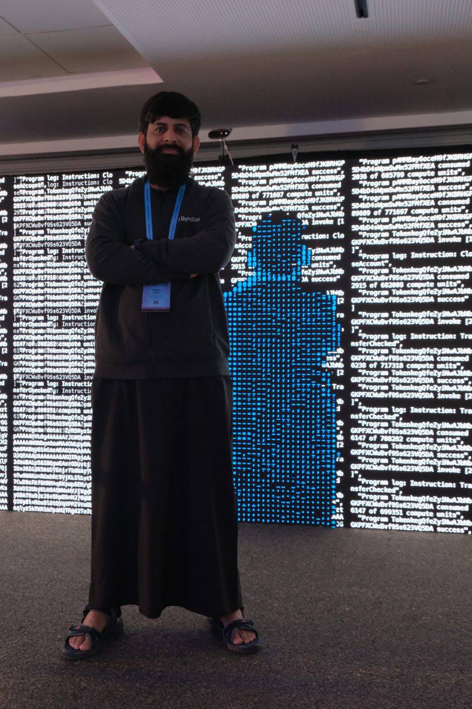 A visitor standing before the wall, their full silhouette rendered in blue ASCII characters