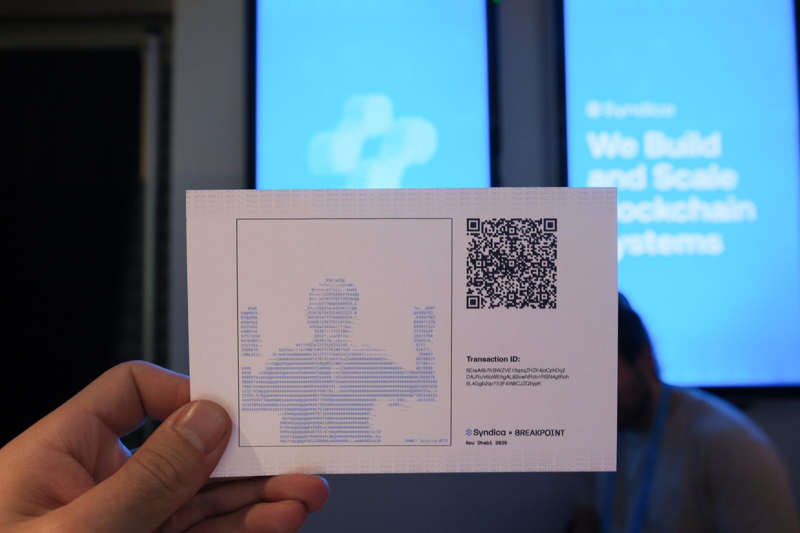 A printed takeaway card showing a visitor's ASCII portrait alongside a QR code