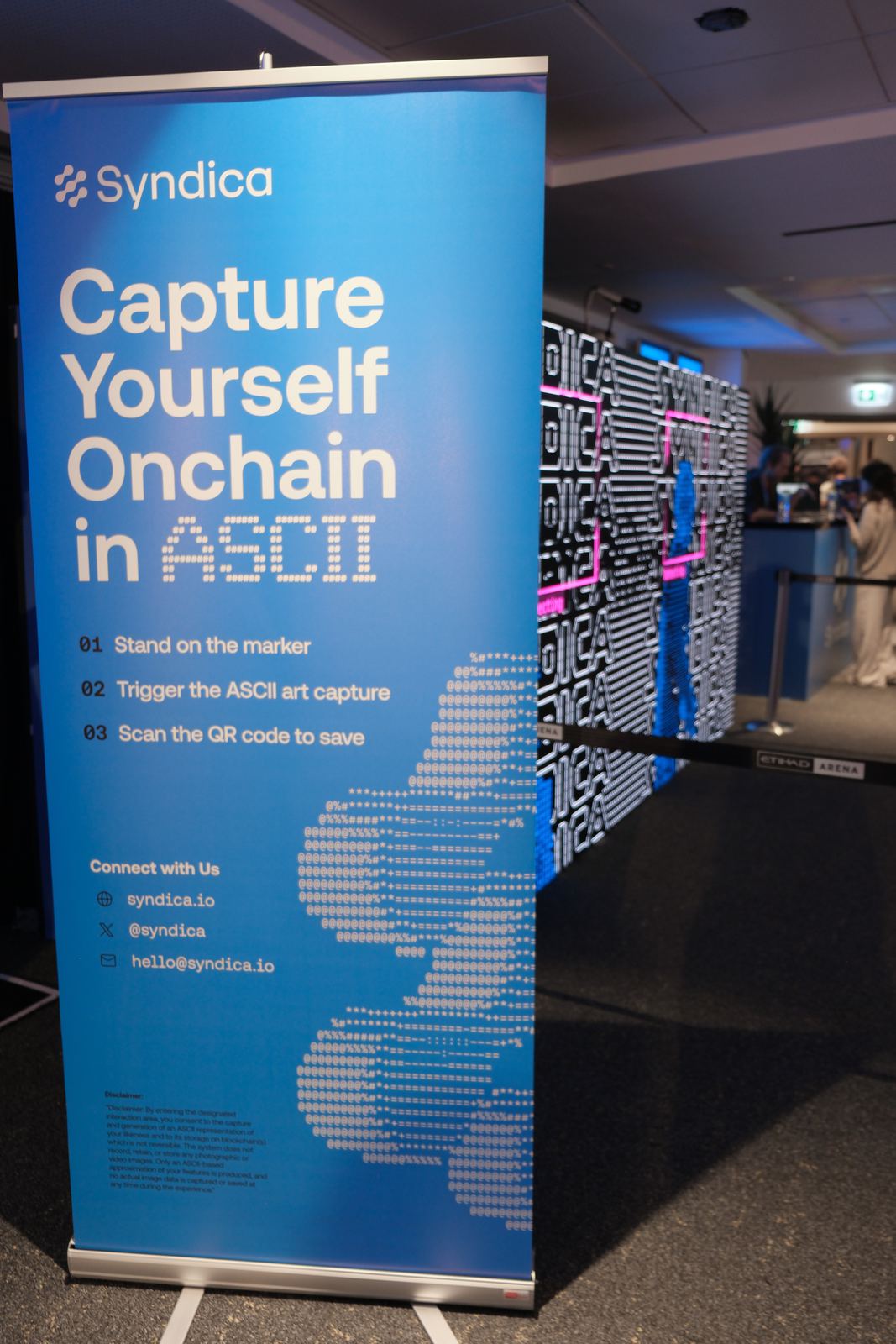 Syndica stand banner reading Capture Yourself Onchain in ASCII with step-by-step instructions